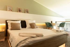 - une chambre avec un grand lit et 2 chaises vertes dans l'établissement VIVO Loft Short Stay, à Baia Mare
