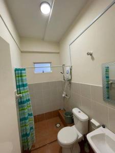 a bathroom with a toilet and a sink and a window at Borneo Cove Seaview Sandakan in Sandakan