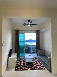 a living room with a couch and a ceiling fan at Borneo Cove Seaview Sandakan in Sandakan