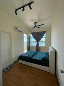 a bedroom with a bed and a ceiling fan at Borneo Cove Seaview Sandakan in Sandakan