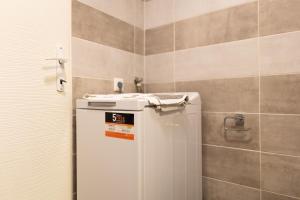 a small refrigerator in a bathroom with a tiled wall at VIVO Loft Short Stay in Baia Mare