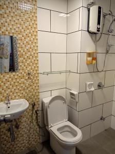 uma casa de banho com um WC e um lavatório em Taiping Centre Point Suite em Taiping