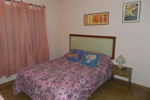 um quarto com uma cama com duas almofadas em Lo de Lili em Puerto Madryn