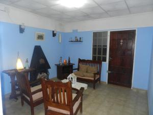a living room with blue walls and wooden chairs at Lo de Lili in Puerto Madryn +15 photos