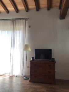 uma sala de estar com televisão numa cómoda com candeeiro em THE RANCH Apartment 2 Capalbio em Pescia Romana