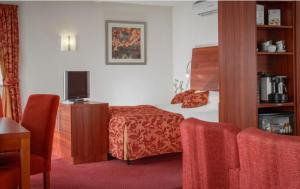 une chambre d'hôtel avec un lit et une télévision dans l'établissement Hotel Greenside Texel, à De Koog