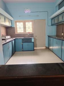 a kitchen with blue cabinets and a white floor at Feel Like Home Rkbeach in Visakhapatnam