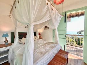 a bedroom with a canopy bed and a balcony at Blow Show Casa III Guest House in Ilhabela +153 photos