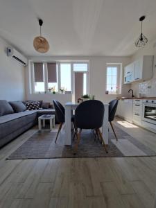 eine Küche und ein Wohnzimmer mit einem Tisch und Stühlen in der Unterkunft Apartman REA 1 in Pirot