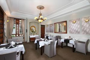 a restaurant with white tables and chairs and a chandelier at The Bedelle in Nairobi