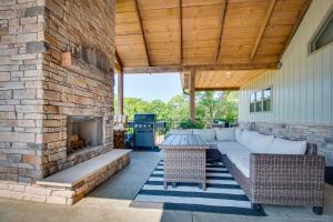 a patio with a couch and a fireplace at Idyllic Williamstown Retreat with Hot Tub and Pool! in Williamstown
