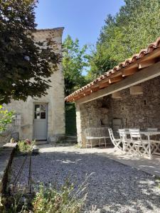 a house with a patio with a table and chairs at La maison du haut in Ponet-et-Saint-Auban