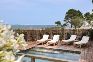 a patio with four chairs and a swimming pool at Résidence Les Suites Pereire in Arcachon