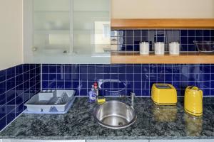 a kitchen counter with a sink and blue tiles at The Tower Bridge Cosy Flat in London