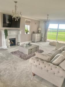 a living room with a couch and a fireplace at Boundary Farm in Middleton