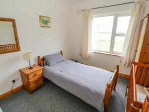 Un pat sau paturi într-o cameră la 13 Trawmore Cottages