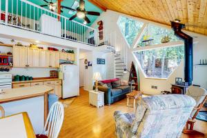 a kitchen and living room with a vaulted ceiling at Bottle Bay Bungalow in Sagle