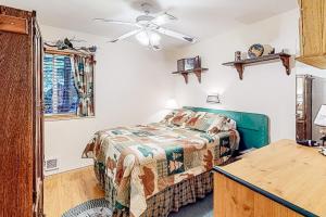 a bedroom with a bed and a ceiling fan at Bottle Bay Bungalow in Sagle