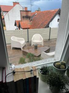 balkon z 2 białymi krzesłami i drewnianym tarasem w obiekcie Apartament Tuchola w Tucholi