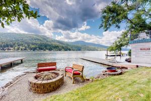 a group of chairs sitting on the shore of a lake at Bottle Bay Bungalow in Sagle