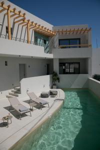 een zwembad met stoelen en een huis bij Anapollo Boutique Hotel Adults Only in Naxos Chora