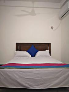 a bedroom with a large bed with blue pillows at SHARAH Beach Resort in Addalachenai