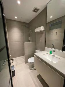 Monde Residence H 15 Batam Centre في Sengkuang: حمام به مرحاض أبيض ومغسلة