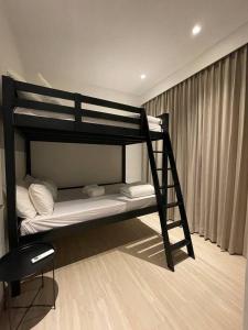 Ce lit superposé se trouve dans un dortoir avec une échelle. dans l'établissement Monde Residence H 15 Batam Centre, à Sengkuang