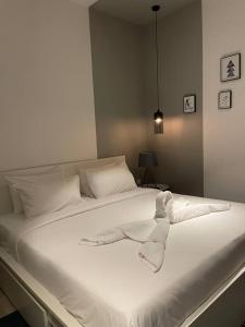 a white bed with white sheets and pillows on it at Monde Residence H 15 Batam Centre in Sengkuang
