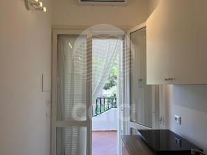 uma cozinha com uma porta de vidro que leva a uma varanda em Room 401 - Piano Primo em Porto Cesareo