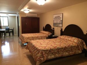 een hotelkamer met 2 bedden en een tafel bij Hotel Milan Panama in Panama-Stad