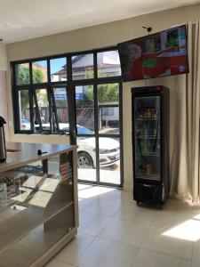 ein Geschäft mit einem Kühlschrank in einem Zimmer mit Fenstern in der Unterkunft Pousada Salomão in Teixeira de Freitas
