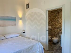 um quarto com uma cama e uma casa de banho com um WC em Room 404 - Piano Primo em Porto Cesareo
