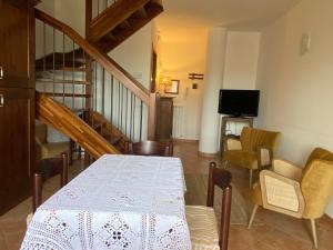 a dining room with a table and chairs and a television at Duplex nuovo e grazioso in Capracotta