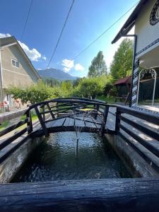 un puente de madera sobre una piscina de agua en Casa Munții Rodnei, en Borşa