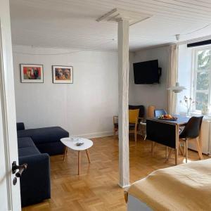 ein Wohnzimmer mit einem blauen Sofa und einem Tisch in der Unterkunft Holsteinshus B&B in Odder