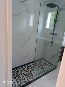une douche en verre avec un carrelage noir et blanc dans l'établissement Bel appartement 6 pers proche de Paris, à Vitry-sur-Seine