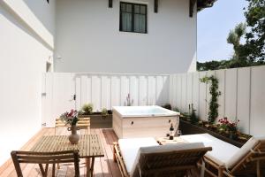 a patio with a wooden table and a tub at Résidence Les Suites Pereire in Arcachon