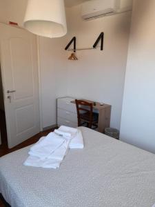 una camera da letto con un letto con due asciugamani bianchi di B&B Il Viaggiatore a Marina di Massa