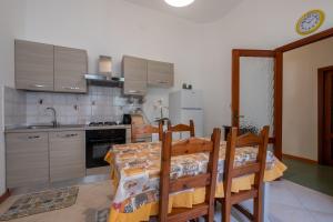 eine Küche mit einem Esstisch und eine Küche mit in der Unterkunft Maison Adriana con giardino - 10 minuti dal Poetto e dal Parco Molentargius in Quartu SantʼElena