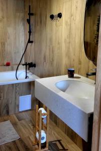 bagno con lavandino bianco e specchio di Apartament pod Grodziskiem 