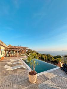 a villa with a swimming pool and the ocean at Blow Show Casa III Guest House in Ilhabela