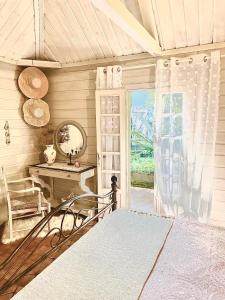 Schlafzimmer mit einem Bett, einem Tisch und einem Spiegel in der Unterkunft La Kaz LANGEVIN in Saint-Joseph