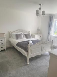 a white bedroom with a bed and two night stands at Boundary Farm in Middleton