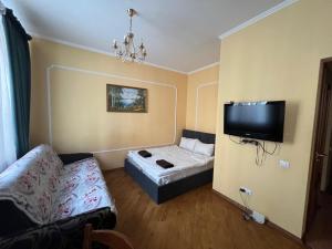 uma sala de estar com um sofá e uma televisão de ecrã plano em Central House em Lviv