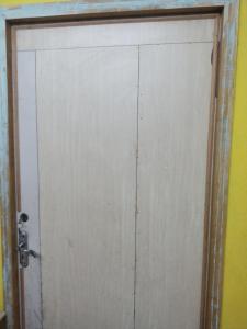 eine weiße Tür in einem Zimmer mit gelber Wand in der Unterkunft Ilamathi hostel in Chennai