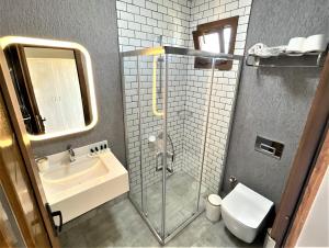 a bathroom with a shower and a sink and a toilet at Naz Liman Otel Bodrum in Bodrum City