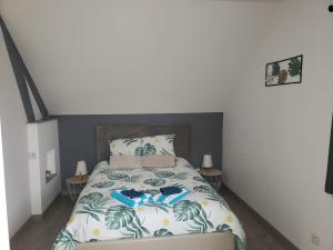 ein Schlafzimmer mit einem Bett und zwei Nachttischen in der Unterkunft Le charmillon, Appartement cosi avec double garage in Mancey