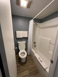 a bathroom with a toilet and a tub and a sink at HillView Inn at Six Flags Fiesta in San Antonio