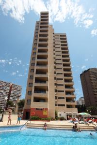 a building with a swimming pool in front of a building at Dynastic Rooms Apartments in Benidorm